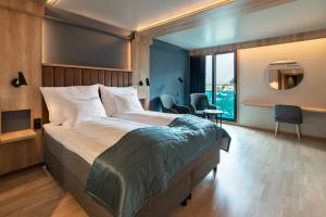 um quarto com uma cama grande e uma janela grande em Quality Hotel Sogndal em Sogndal
