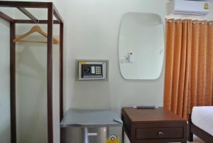 a room with a bed and a mirror and a table at Baan Taweesuk Guest House in Hua Hin
