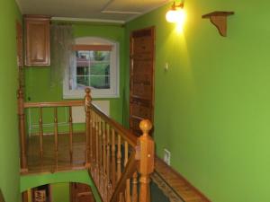 a green room with a staircase and a window at Spacious Holiday Home in Stara Kamienica with Pond in Stara Kamienica