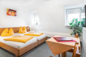 two beds in a room with yellow pillows on them at Brauhaus Gummersbach GmbH in Gummersbach