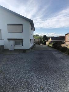 una casa blanca en una entrada de grava en Vivere, en Aan de Wolfsberg