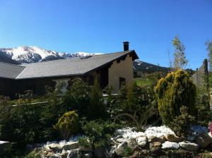 a house with snow covered mountains in the background at Lyshytta in Saint-Pierre-dels-Forcats