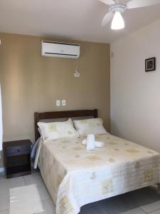 a bedroom with a bed with a white fan at Recanto do Teimoso suites in Ubatuba