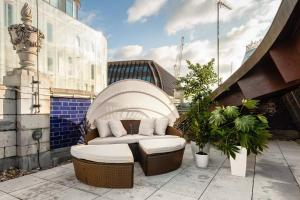 eine Terrasse mit einem Sofa und Stühlen auf einem Gebäude in der Unterkunft Hausd - Piccadilly Circus in London