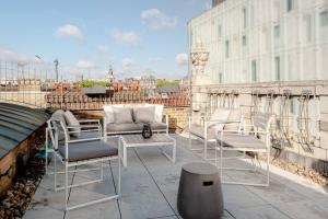 eine Gruppe Stühle und ein Tisch auf dem Balkon in der Unterkunft Hausd - Piccadilly Circus in London