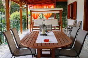 a wooden table and chairs on a patio at Renaissance Holidays Villa in Nea Kalikratia