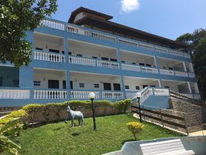 a goat standing in front of a building at Pousada Recanto do Teimoso in Ubatuba