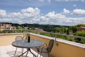 una mesa y sillas en un balcón con vistas en Porta Pispini Residence, en Siena