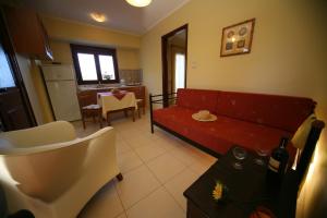 カルファスにあるEfta Anemi - Benoviasのリビングルーム(赤いソファ付)、キッチン
