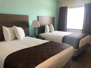 a hotel room with two beds and a window at Mariner Inn in Galveston