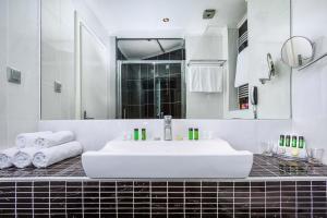 a white bathroom with a sink and a mirror at Elinotel Apolamare Hotel in Hanioti