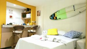 a room with a bed and a surfboard on the wall at Pipa's Ocean - Flat Vista Mar in Pipa