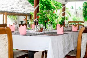 einen weißen Tisch mit rosa Kissen darüber in der Unterkunft Hotel Ganiela in Palimé