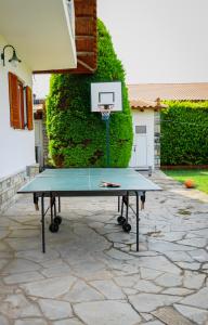 a ping pong table with a basketball hoop in a backyard at Renaissance Holidays Villa in Nea Kalikratia