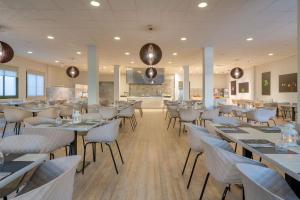 restauracja ze stołami i krzesłami w pokoju w obiekcie Apartamentos Santa Rosa w Costa Teguise