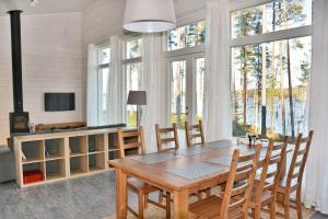 a dining room with a table and chairs and windows at ONNI Village in Ruokolahti