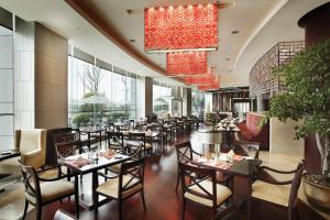 a restaurant with tables and chairs in a room with windows at Holiday Inn Chengdu Century City - East, an IHG Hotel in Chengdu