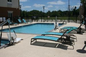 uma piscina com espreguiçadeiras em Candlewood Suites College Station, an IHG Hotel em Bryan