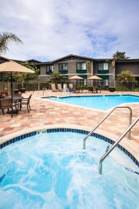 a pool with tables and umbrellas at a hotel at Holiday Inn Express & Suites Carpinteria, an IHG Hotel in Carpinteria