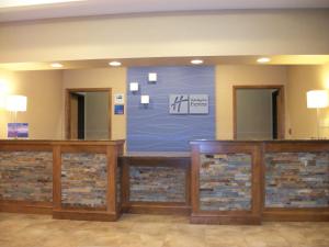 a lobby with a large blue sign on the wall at Holiday Inn Express - Cortland, an IHG Hotel in Cortland