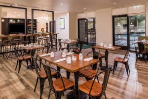 a dining room with wooden tables and chairs at Holiday Inn and Suites Addison, an IHG Hotel in Addison