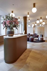 eine Lobby mit einer Vase Blumen auf dem Tresen in der Unterkunft Hotel Walhalla in St. Gallen