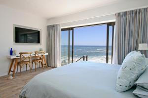 a bedroom with a bed and a view of the ocean at Beach Music in Llandudno