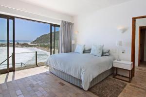 a bedroom with a bed with a view of the ocean at Beach Music in Llandudno