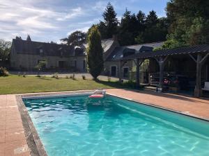 a swimming pool in front of a house at Domaine de la Prévostais in Pleucadeuc