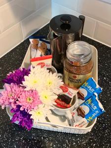 a tray with flowers and food on a counter at Serviced Apartment Bristol One-Bedroom Southmead Hospital MOD Airbus in Bristol