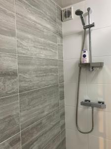 a bathroom with a shower with a tile wall at Serviced Apartment Bristol One-Bedroom Southmead Hospital MOD Airbus in Bristol