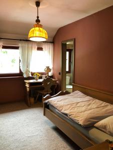 a bedroom with a bed and a desk and a lamp at Gasthof Adler in Weinstadt