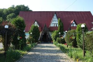una casa con techo rojo y pasarela en Турянська долина en Perechin
