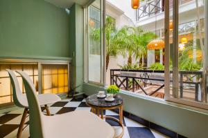 ハノイにあるOhana Hotelのテーブルと椅子、バルコニーが備わる客室です。