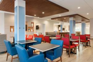 uma área de jantar com mesas e cadeiras numa cafetaria em Holiday Inn Express & Suites - Cincinnati NE - Red Bank Road, an IHG Hotel em Cincinnati