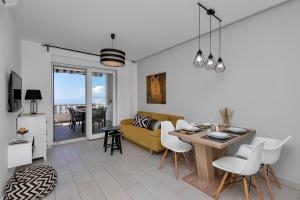 een woonkamer met een gele bank en een tafel bij Apartments Villa Joy in Podgora
