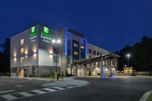 a large building with a parking lot at night at Holiday Inn Express & Suites Charlotte - Ballantyne, an IHG Hotel in Charlotte