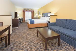 une chambre d'hôtel avec un lit et un canapé dans l'établissement Holiday Inn Express & Suites Denver North - Thornton, an IHG Hotel, à Thornton