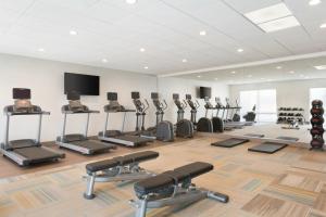 a gym with rows of exercise bikes and a flat screen tv at Holiday Inn Express & Suites - Cincinnati NE - Red Bank Road, an IHG Hotel in Cincinnati