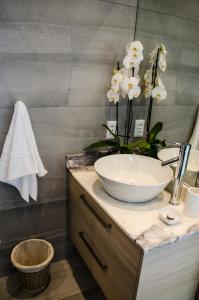 a bathroom with a bowl sink and flowers on a counter at Lavinia Lifestyle in Stellenbosch