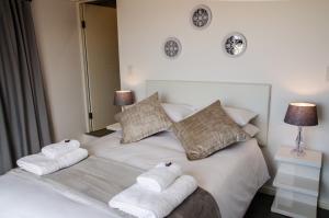 a bedroom with a white bed with towels on it at Lavinia Lifestyle in Stellenbosch