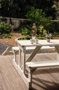 un tavolo da picnic con due panche e una statua di Lavinia Lifestyle a Stellenbosch