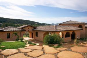 a house with a stone path in front of it at Hotel Giardino Corte Rubja in Iglesias