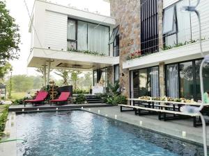 una casa con piscina accanto a un edificio di Flamingo Dai Lai Resort - by BAY LUXURY a Yen