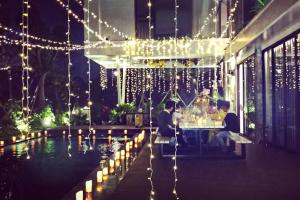 due persone sedute a un tavolo in un edificio con luci di Flamingo Dai Lai Resort - by BAY LUXURY a Yen Altre 100 foto