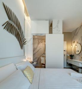 a bedroom with a white bed and a bathroom at Le Palmette Suites in Cagliari