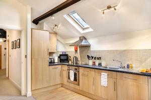 a kitchen with wooden cabinets and a skylight at The Old Sweet Factory in Harrogate