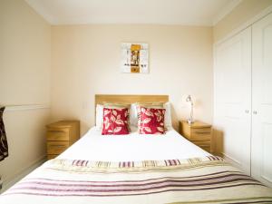 1 dormitorio con 1 cama blanca grande con almohadas rojas en OYO White Horse Lodge Hotel, East Thirsk, en Thirsk