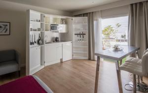 a kitchen with white cabinets and a table and a window at Flamingo Beach Mate in Adeje