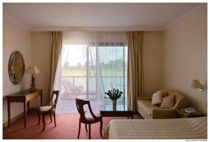 a hotel room with a bedroom with a bed and a desk at Relais de Margaux - Hôtel & Spa in Margaux